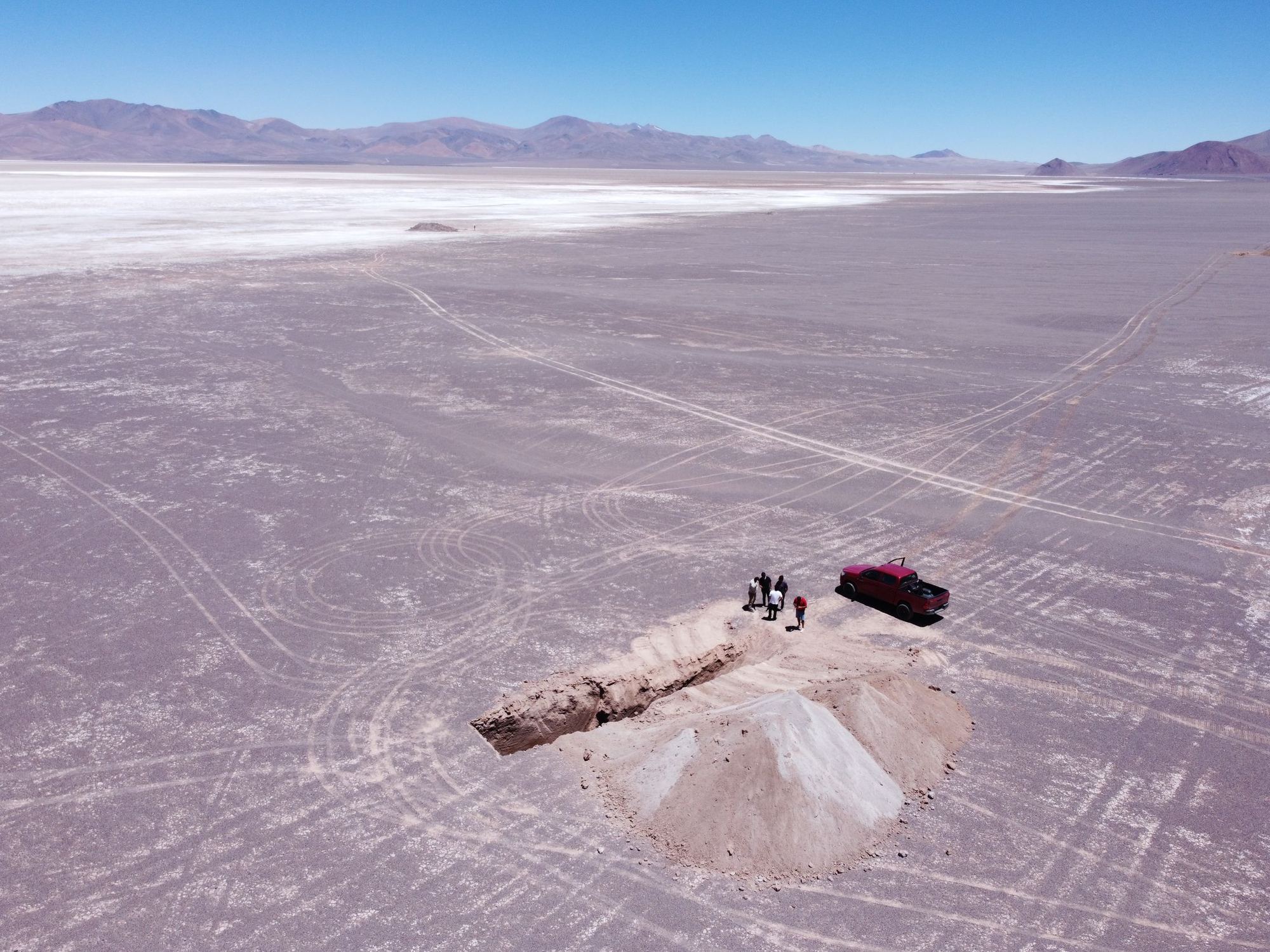 Vista aérea del equipo junto a una calicata en la costra blanca del Salar de Maricunga